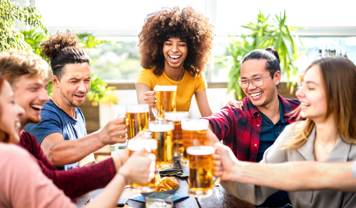 amigos felizes brindando com copos de cervejas