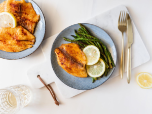 Mesa posta com prato principal composto por peixe grelhado