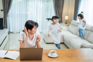 Mãe estressada tentando conciliar trabalho e cuidar dos filhos