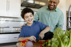 Pai e filho cozinhando juntos alegremente 