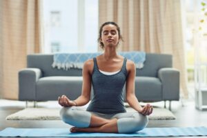 mulher praticando yoga na sua sala de estar