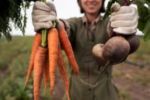 agricultora segurando legumes típicos do mês de maio