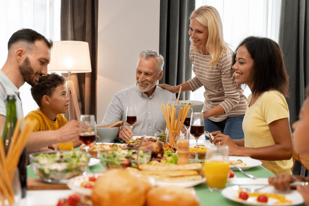 Uma família reunida em torno de uma mesa, desfrutando de um almoço de Dia dos Pais, com pratos variados e taças de vinho, enquanto compartilham risadas e momentos especiais.