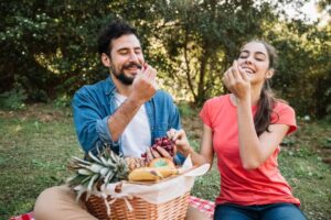 Casal em um piquenique comendo frutas da estação  