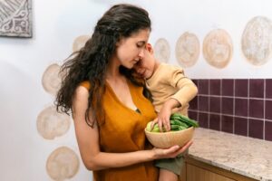 Mãe cozinhando com seu filho para facilitar a transição alimentar para o veganismo