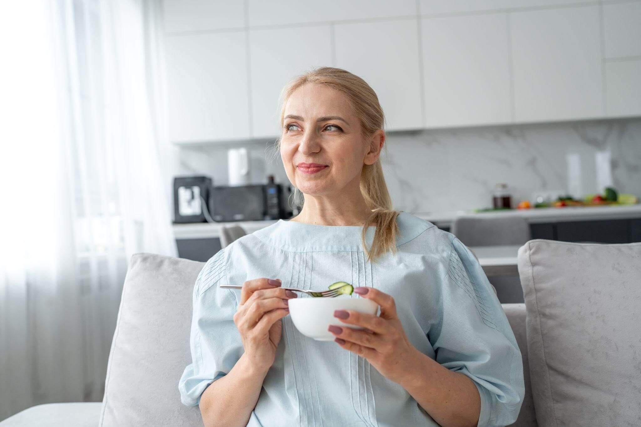 Mulher se alimentando de forma corretamente durante os sintomas da menopausa.