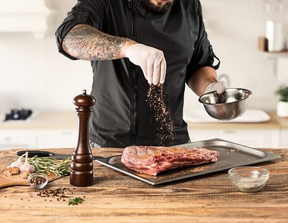 Homem ensinando a como temperar carne para churrasco.